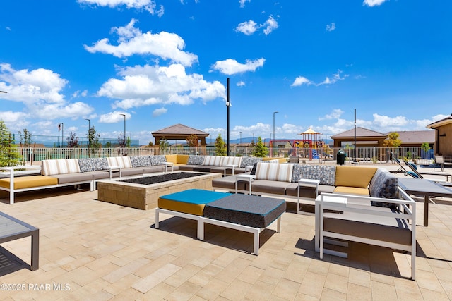 view of patio featuring a gazebo and an outdoor living space with a fire pit