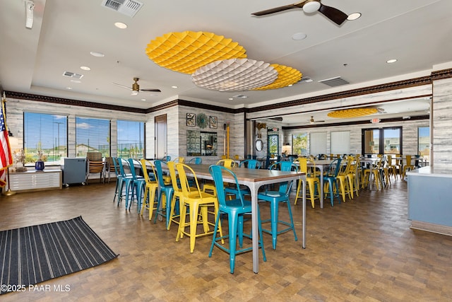 dining room with a tray ceiling, a wealth of natural light, and ceiling fan