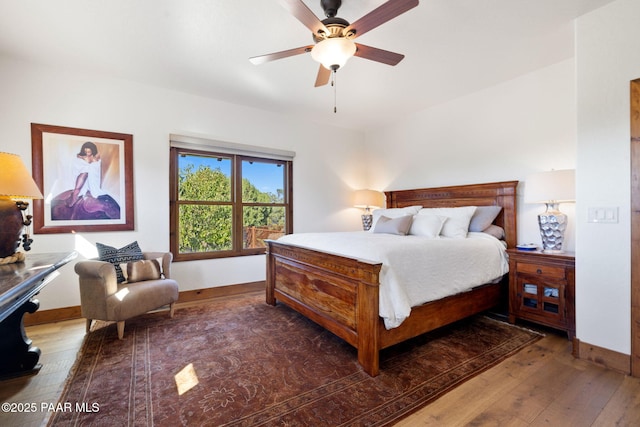 bedroom with a ceiling fan, dark wood-type flooring, and baseboards