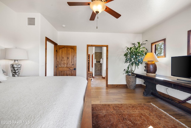 bedroom featuring a ceiling fan, wood finished floors, visible vents, and baseboards