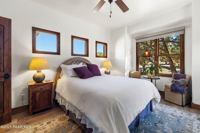 bedroom featuring wood finished floors, baseboards, and ceiling fan