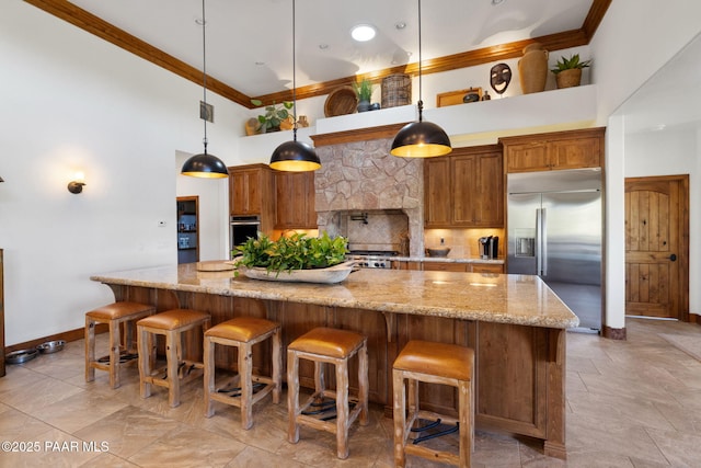 kitchen with tasteful backsplash, a spacious island, stainless steel built in fridge, ornamental molding, and a towering ceiling