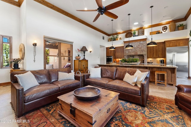 living room featuring a towering ceiling, a ceiling fan, and crown molding