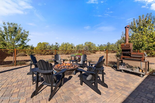 view of patio with an outdoor fire pit and fence