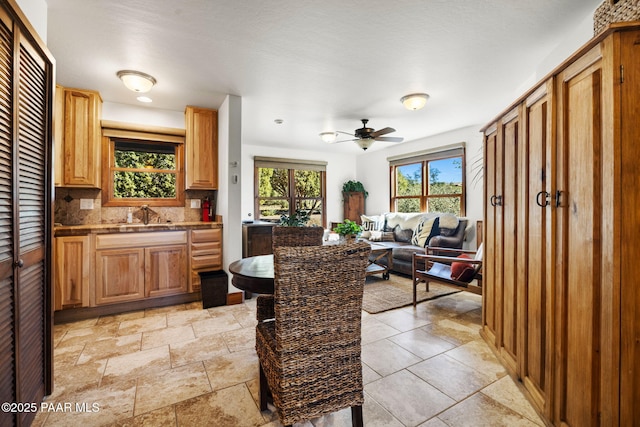 dining area featuring stone finish flooring and ceiling fan