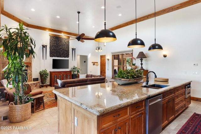 kitchen featuring light stone counters, a kitchen island with sink, ceiling fan, a sink, and open floor plan