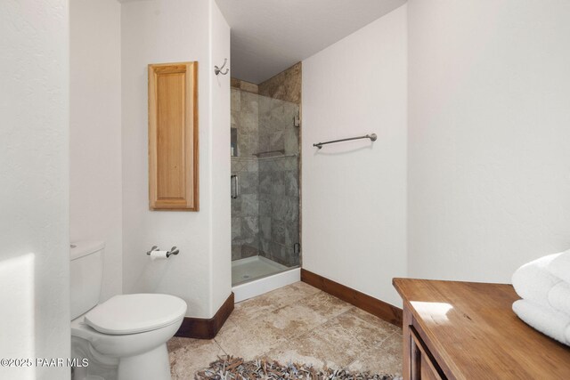 bathroom featuring tile patterned floors, toilet, baseboards, and a stall shower