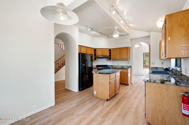 1893 Forest Vw, Prescott, AZ 86305 - kitchen with black refrigerator with ice dispenser, arched walkways, a sink, a kitchen island, and under cabinet range hood