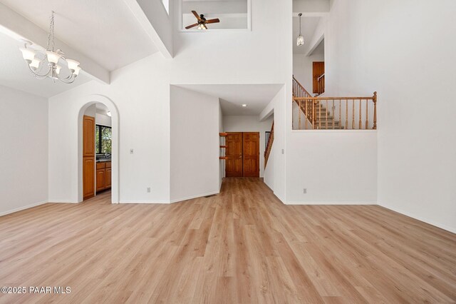 1893 Forest Vw, Prescott, AZ 86305 - unfurnished living room featuring light wood finished floors, arched walkways, stairway, ceiling fan, and baseboards