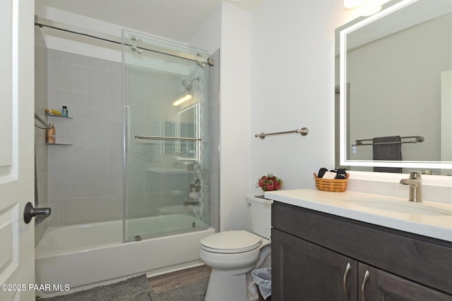 bathroom featuring wood finished floors, vanity, toilet, and bathing tub / shower combination