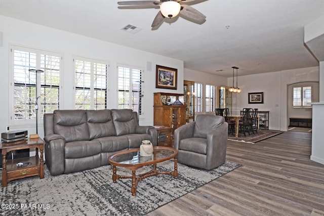 living room featuring visible vents, ceiling fan, a wealth of natural light, and wood finished floors