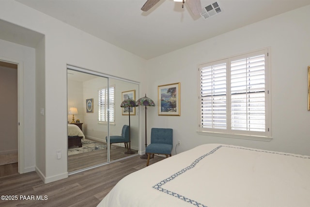 bedroom featuring a closet, multiple windows, wood finished floors, and visible vents