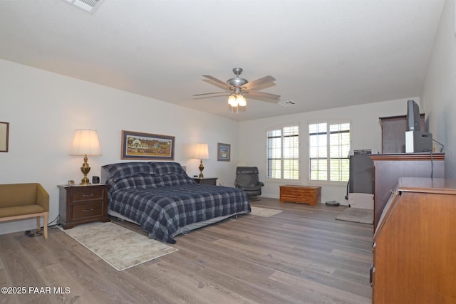 bedroom with visible vents, ceiling fan, light wood-style flooring, and baseboards