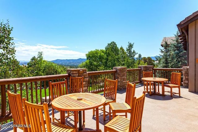 wooden deck with a mountain view and outdoor dining area