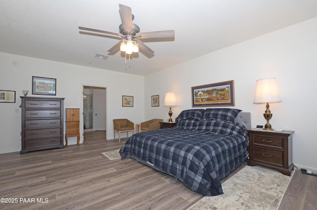 bedroom with visible vents, wood finished floors, and ceiling fan