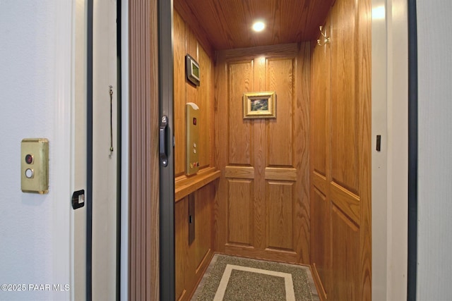 interior details with recessed lighting, wooden walls, and elevator