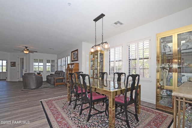dining space featuring visible vents, ceiling fan, wood finished floors, and baseboards