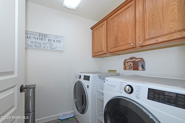 laundry room featuring baseboards, cabinet space, and washing machine and clothes dryer