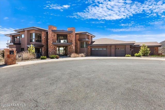 7420 E Reins Ct, Prescott Valley, AZ 86314 - view of front of house featuring an attached garage, a chimney, driveway, and stone siding