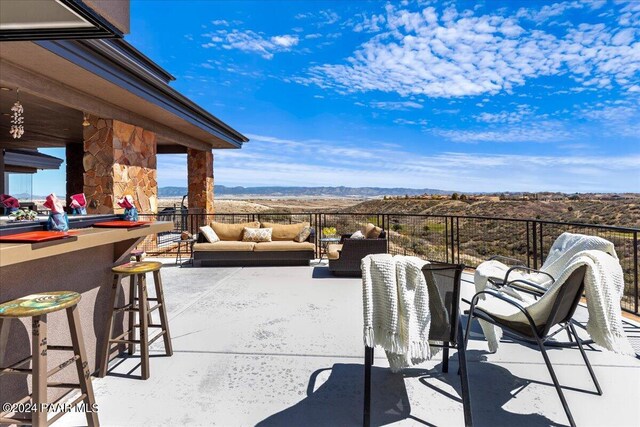 7420 E Reins Ct, Prescott Valley, AZ 86314 - view of patio with outdoor lounge area, a mountain view, and exterior bar