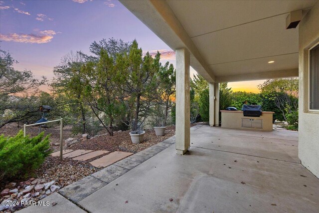 patio terrace at dusk with exterior kitchen