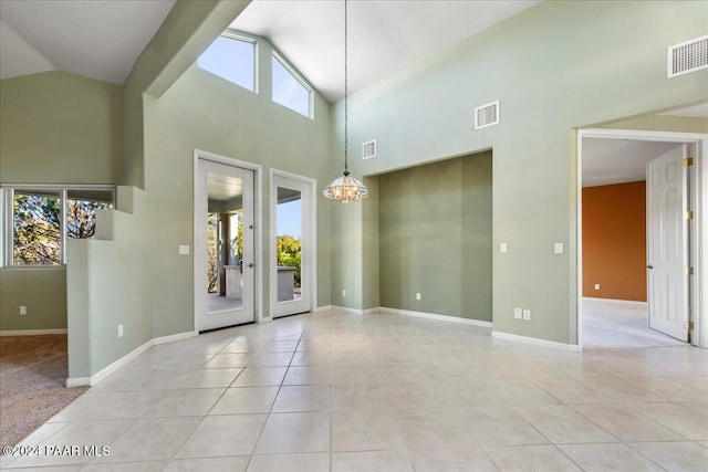 foyer entrance featuring a chandelier, light tile patterned floors, and a healthy amount of sunlight