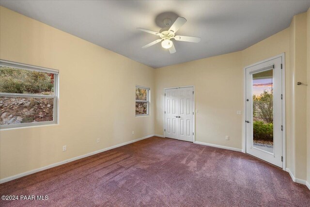 unfurnished bedroom featuring carpet, access to exterior, a closet, and ceiling fan