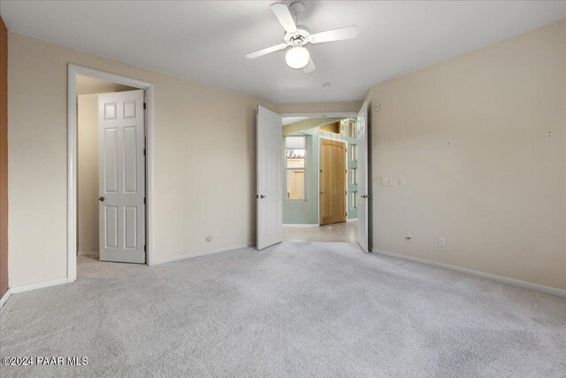 unfurnished bedroom featuring ceiling fan and light carpet