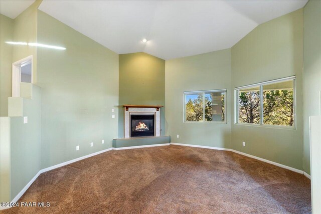 unfurnished living room featuring carpet and lofted ceiling