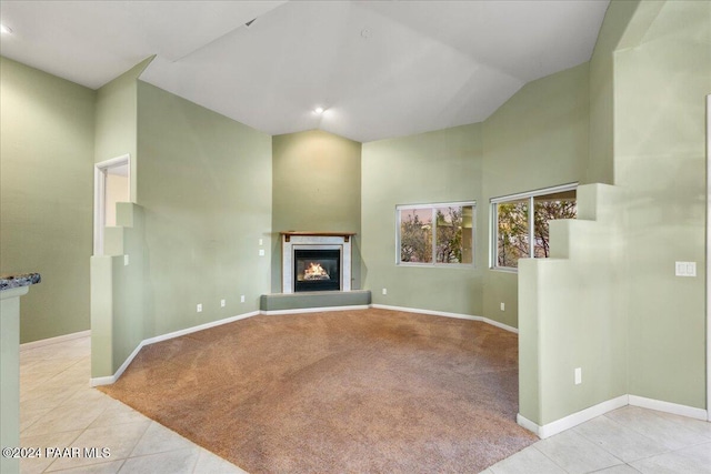 unfurnished living room featuring light colored carpet and vaulted ceiling