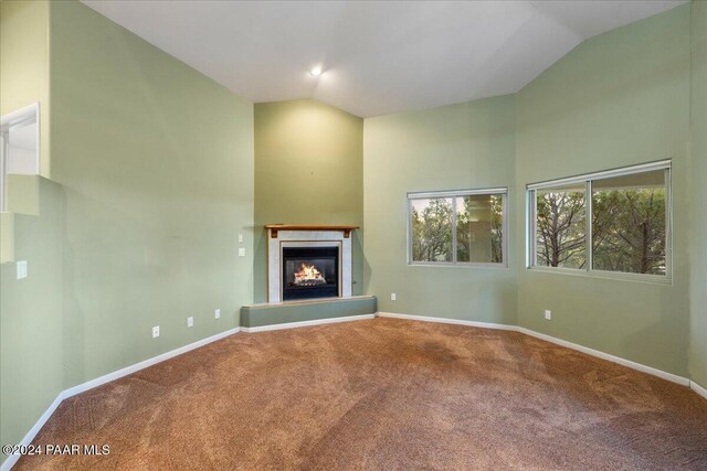 unfurnished living room with lofted ceiling and carpet floors