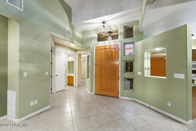 foyer with a high ceiling and light tile patterned flooring