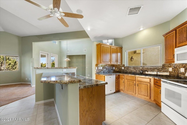 kitchen featuring decorative backsplash, dark stone counters, white appliances, ceiling fan, and light tile patterned floors