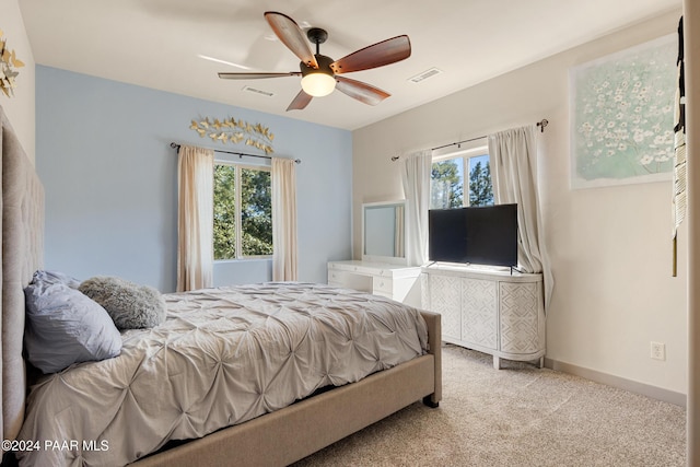 carpeted bedroom with multiple windows and ceiling fan