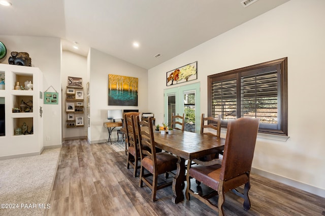 dining room featuring wood-type flooring, lofted ceiling, and french doors