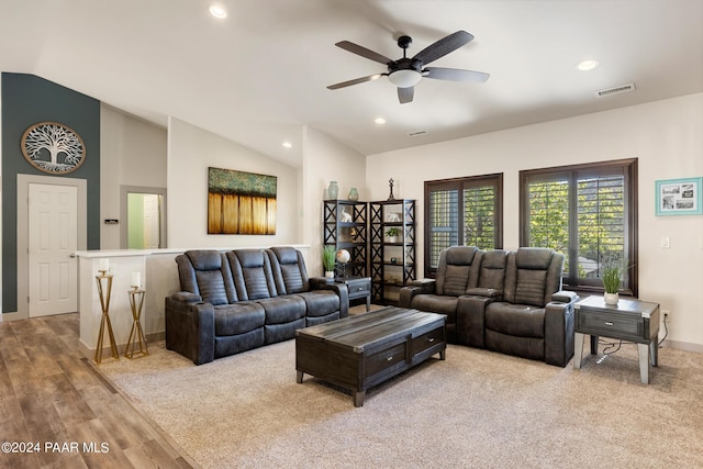 living room with ceiling fan, light hardwood / wood-style flooring, and vaulted ceiling