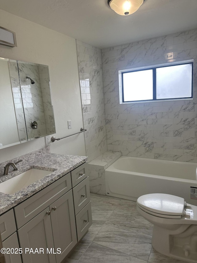 full bathroom featuring tiled shower / bath combo, vanity, and toilet