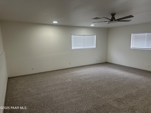 carpeted spare room featuring ceiling fan