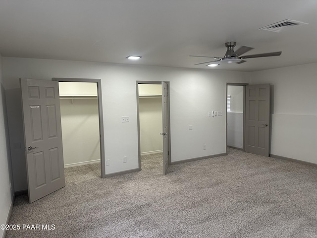 unfurnished bedroom with carpet floors, a walk in closet, and ceiling fan