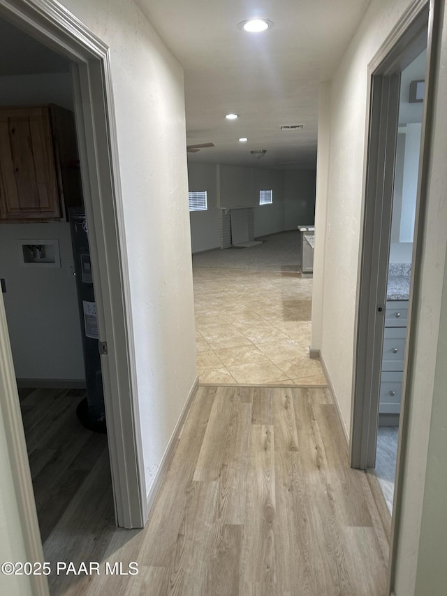 hallway featuring water heater and light wood-type flooring