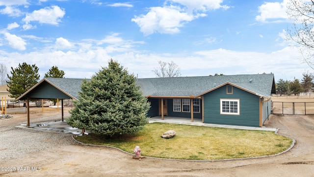 view of front of house featuring a shingled roof, a front lawn, and fence