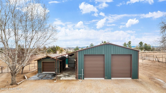 detached garage featuring fence