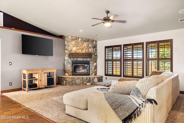 living area with visible vents, a ceiling fan, wood finished floors, a fireplace, and lofted ceiling