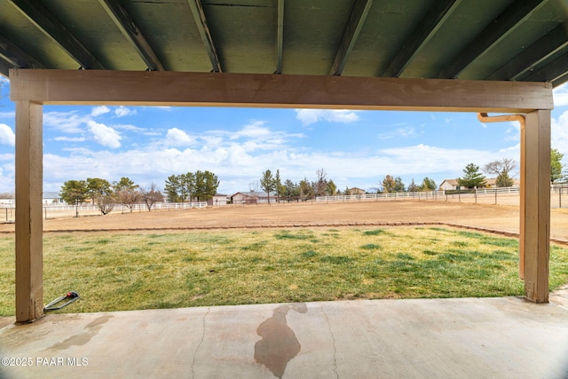 view of patio / terrace featuring a rural view and fence