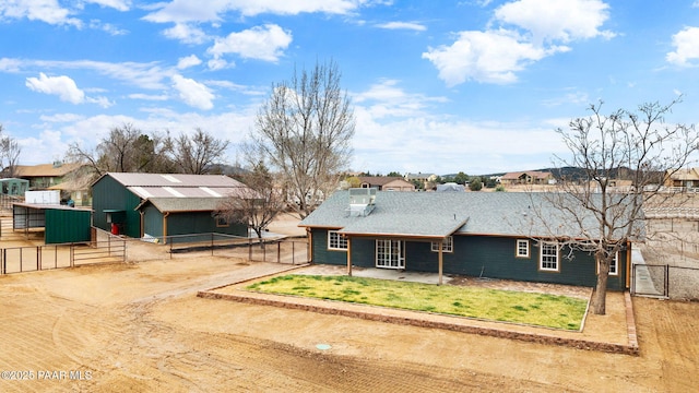 ranch-style home with fence, a front yard, an outbuilding, a patio, and a gate