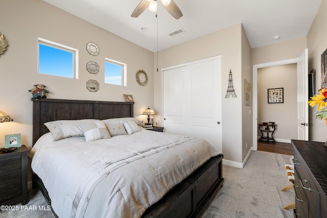 carpeted bedroom with a ceiling fan, a closet, visible vents, and baseboards