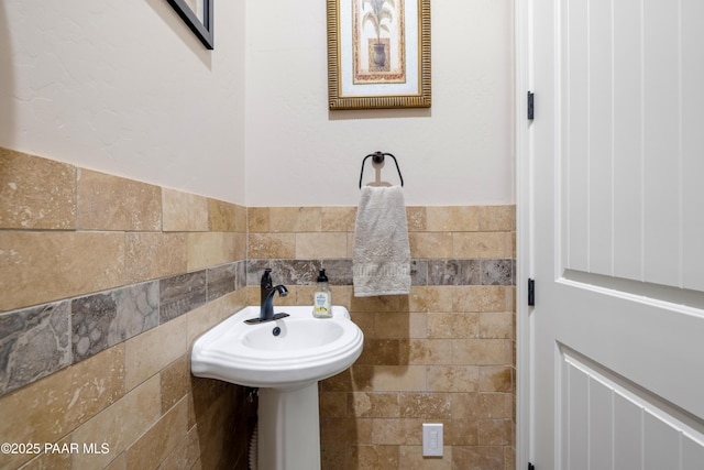 bathroom with a wainscoted wall and tile walls