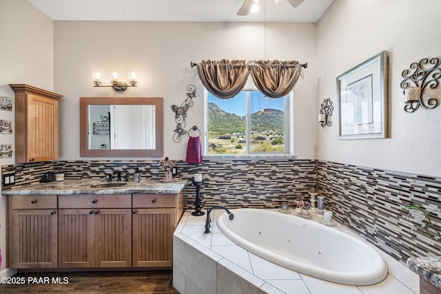 bathroom with a whirlpool tub, backsplash, vanity, and a ceiling fan