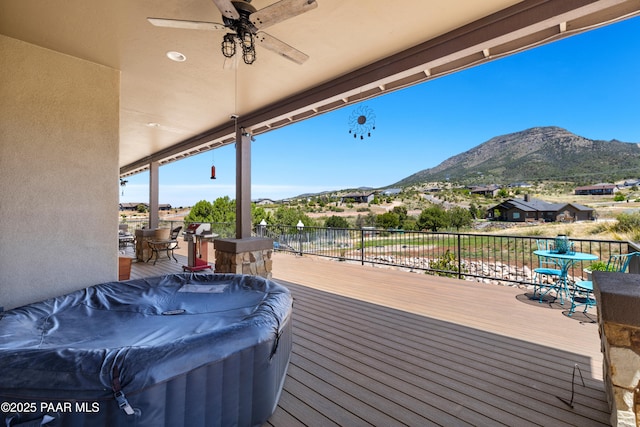 deck with ceiling fan, outdoor dining space, and a mountain view