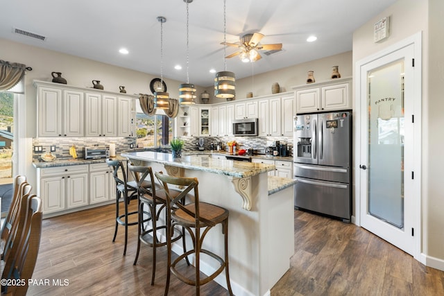 kitchen featuring appliances with stainless steel finishes, dark wood-style flooring, and visible vents